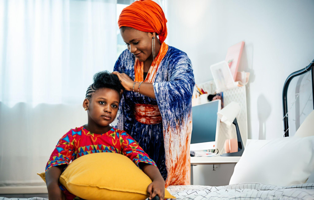 A Nigerian parent and child together in traditional cultural attire — passing down heritage through everyday dress