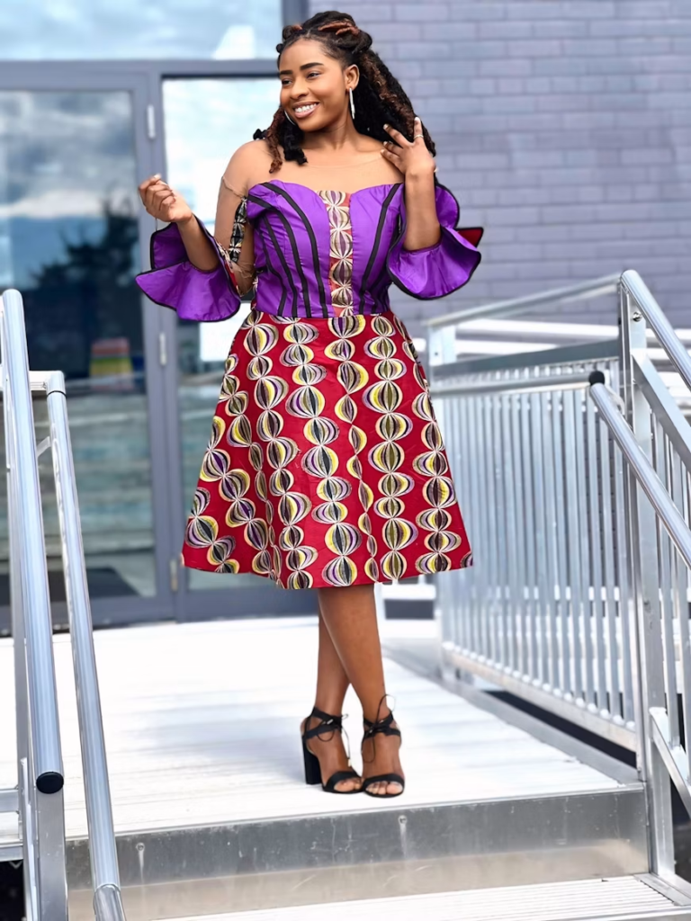 A Nigerian professional in traditional Ankara attire standing confidently in a modern office environment